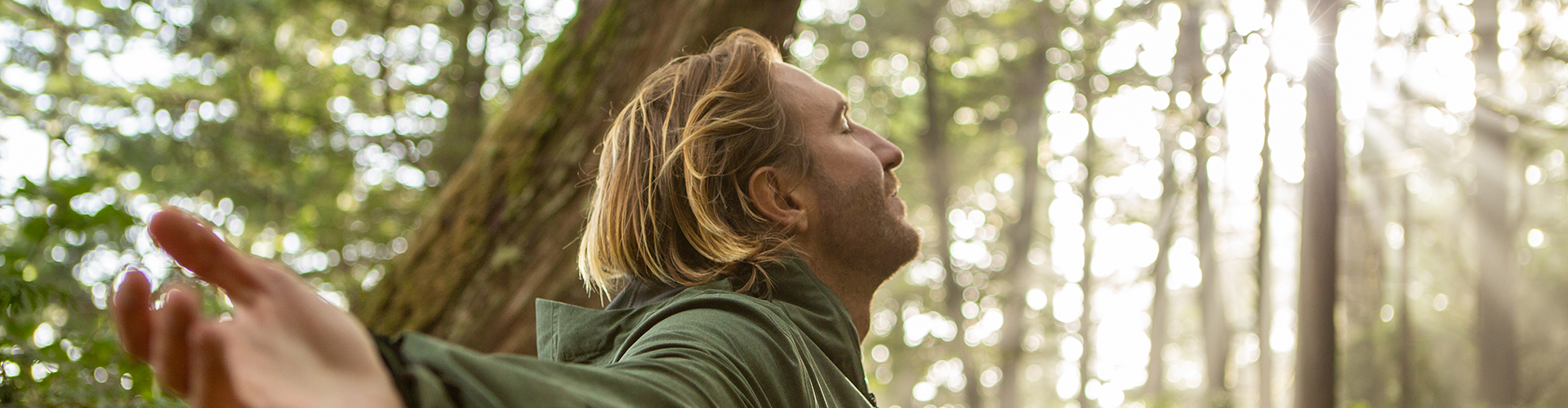 Junger man geniesst die Natur im Wald